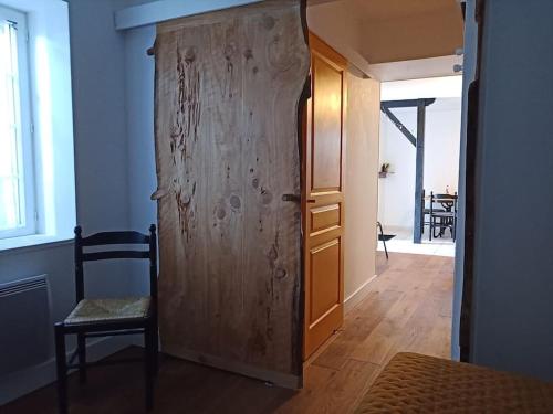 a wooden door in a room with a table at Petite maison de charme Les Chats Pîtres in La Rochette
