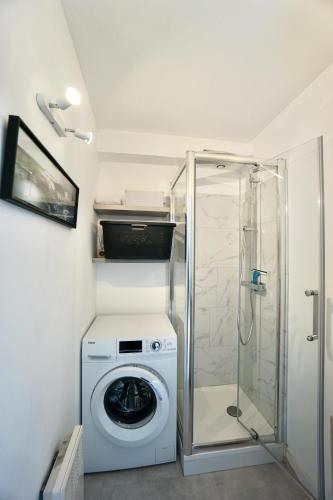 une machine à laver dans une salle de bain avec douche dans l'établissement Les Alizés*200m de la mer*, à Trégunc