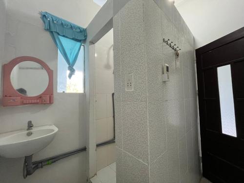 a bathroom with a sink and a shower with a mirror at Trang Vu Homestay Cu Lao Cham in Tân Hiệp