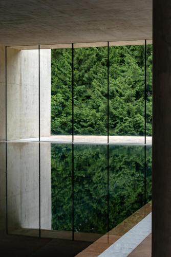 a glass door with a view of a forest at Cowley Manor Experimental in Cheltenham