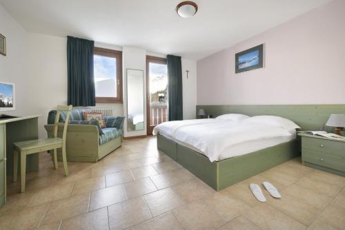 Schlafzimmer mit einem Bett, einem Schreibtisch und einem Stuhl in der Unterkunft Hotel Tambò in Campodolcino