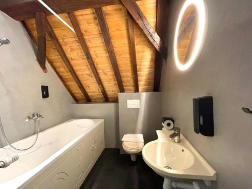 ein Badezimmer mit einer weißen Badewanne, einem WC und einem Waschbecken in der Unterkunft Hector Zierikzee in Zierikzee