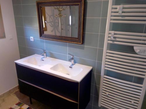 ein Badezimmer mit Waschbecken und Spiegel in der Unterkunft gîte les jardins d'esteban in Tourville-sur-Sienne