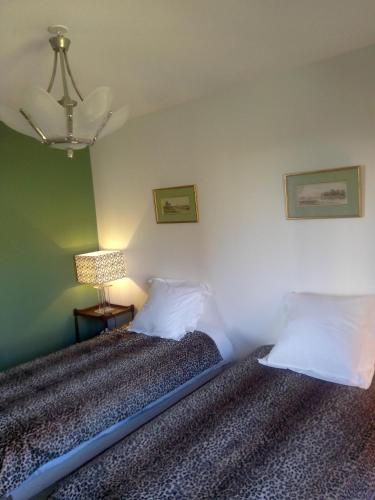 une chambre avec un lit et une lampe sur une table dans l'établissement gîte les jardins d'esteban, à Tourville-sur-Sienne