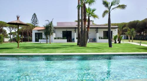 Villa con piscina frente a una casa en Alojamiento rural FINCA AZUCENA SUITE, en Conil de la Frontera