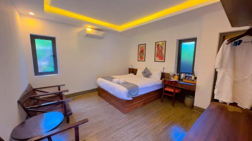 a bedroom with a bed and a desk and two windows at Sapa Eco Villas & Spa in Sa Pa