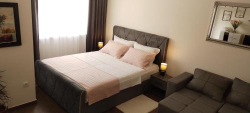 a bedroom with a bed and a couch at Apartman 007 in Kragujevac