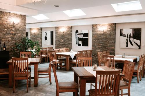 a restaurant with tables and chairs and brick walls at Hotel Centrum Prizren in Prizren