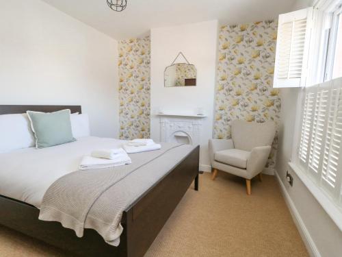 um quarto com uma cama e uma cadeira em Leo's Place em Weymouth