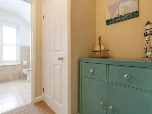 uma casa de banho com uma cómoda azul e uma casa de banho em Leo's Place em Weymouth