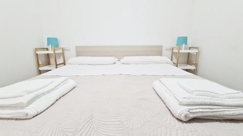 トルトリにあるBivano Faro Bellavistaの白い部屋のベッド2台(タオル付)