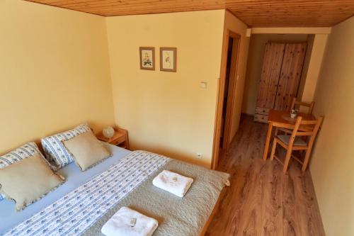 a bedroom with a bed with two towels on it at Chata Harmonie in Bedřichov