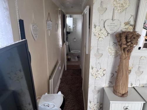 a bathroom with a tv and a vase on a table at Chalet 71 in Leysdown-on-Sea