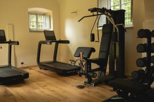 a gym with several tread machines in a room at Villa di Piazzano - Small Luxury Hotels of the World in Cortona