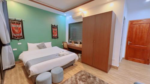 a bedroom with a white bed and a wooden cabinet at Sapa Eco Villas & Spa in Sa Pa