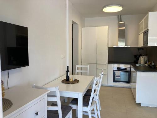 a kitchen with a white table and white chairs at Casa di Giorgio in Jelsa