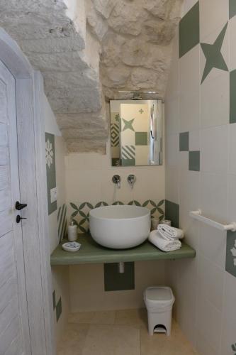 a bathroom with a sink and a toilet at Trullo Vino & Amore in Alberobello