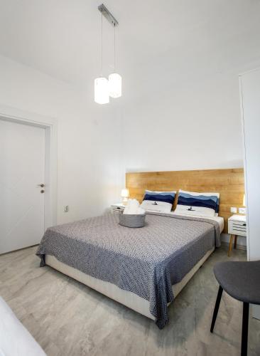 a white bedroom with a large bed with blue pillows at Marti Garden Suites in Skala Prinou