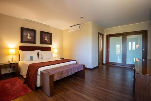 a hotel room with a bed and a sliding glass door at Vila Gale Cascais in Cascais
