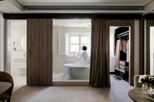 a woman in a bath tub in a bathroom at Palacio de los Duques Gran Meliá - The Leading Hotels of the World in Madrid