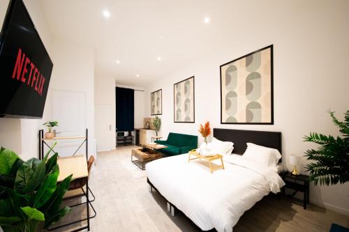 ein Schlafzimmer mit einem Bett und ein Wohnzimmer in der Unterkunft NG SuiteHome - Lille I Roubaix Barbieux I Croix - Balnéo - Relax area - Netflix - Wifi - Kitchenette in Roubaix