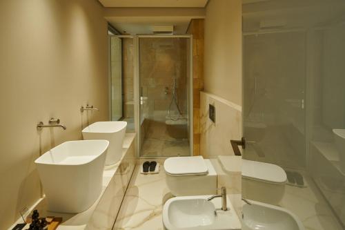 a bathroom with two toilets and a sink and a shower at Palazzo Sangiorgio in Catania