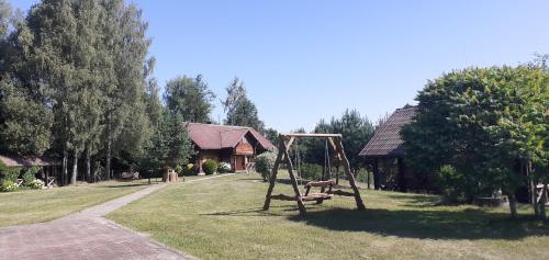 a swing set in the grass in front of a house at Vila Mera in Pabradė