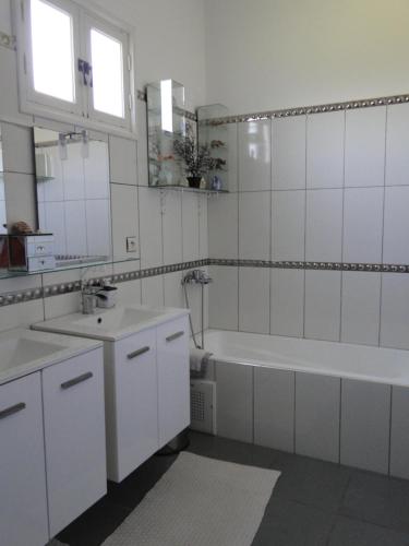 a white bathroom with a tub and a sink at maison calme et reposante in Essaouira