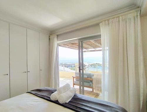 a bedroom with a bed and a large window at Ursula's Upmarket Apartment - Panoramic Views, Large Patio - Braai, WIFI - DSTV in Plettenberg Bay