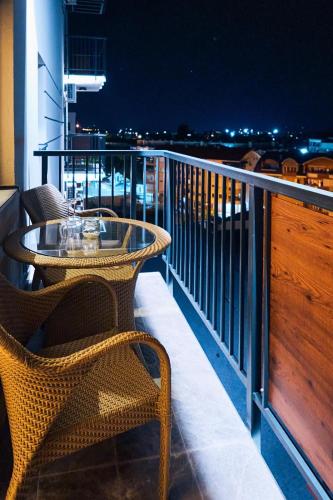 a table and chairs on a balcony at night at Cozy and Lovely Apartments I & II in Jagodina