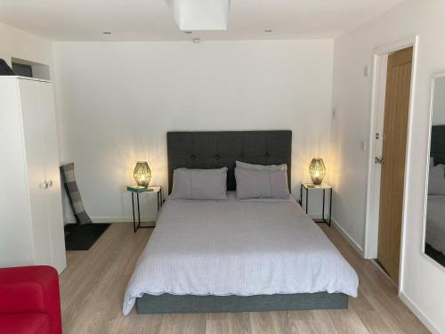 a bedroom with a large white bed with two lamps at Beautiful detached private annex in great location in Manchester