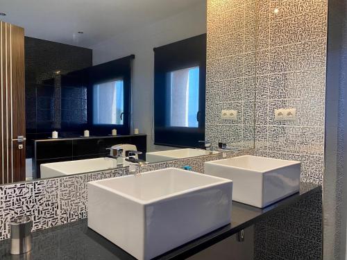 a bathroom with two sinks and a large mirror at Casacastillo28 in Peñarroya de Tastavins