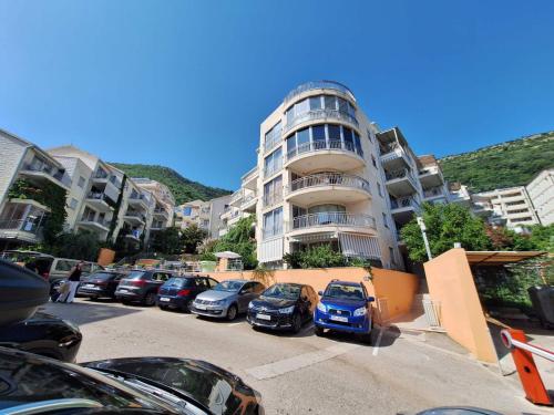 un parking avec des voitures garées devant un bâtiment dans l'établissement Ljiljana, à Petrovac na Moru