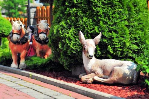 three statues of a deer and horses in a garden at Pod Tatrami 1 - świetna lokalizacja - sauna fińska oraz infrared i grota solna - jedno wejście gratis in Białka Tatrzanska