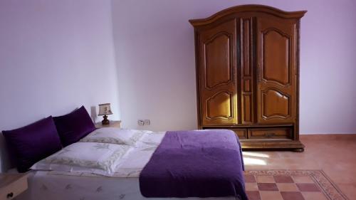 maison calme et reposante في الصويرة: غرفة نوم بسرير وخزانة خشبية