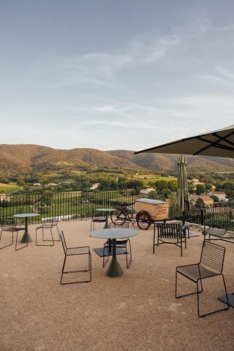 a group of tables and chairs and an umbrella at Le Pavadou B&B in Méthamis