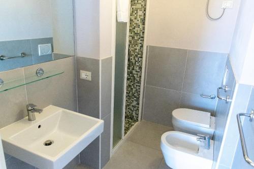 uma casa de banho com um lavatório, um WC e um chuveiro em Elbamar Procchio em Procchio
