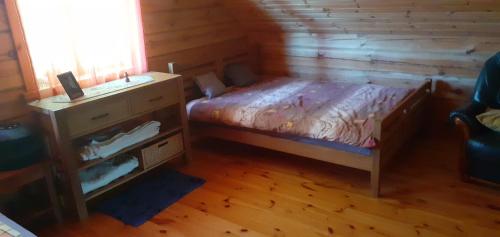 ein kleines Schlafzimmer mit einem Bett und einem Schreibtisch in der Unterkunft Vila Mera in Pabradė