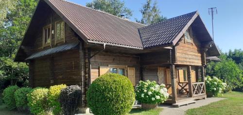 a small wooden house with a brown roof at Vila Mera in Pabradė