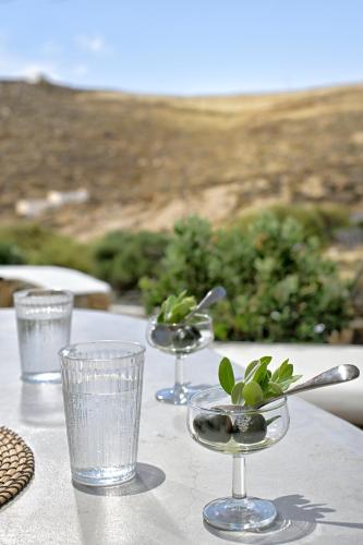 a table with two wine glasses on top of it at VLIA MAR Myconian Residences in Kalafatis