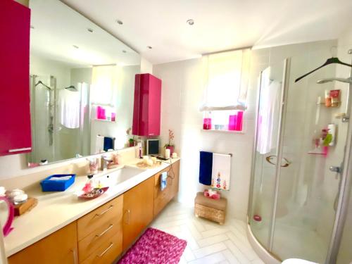 een badkamer met rode kasten, een douche en een wastafel bij Seeview rooftop house between Sorrento and Amalfi in Massa Lubrense