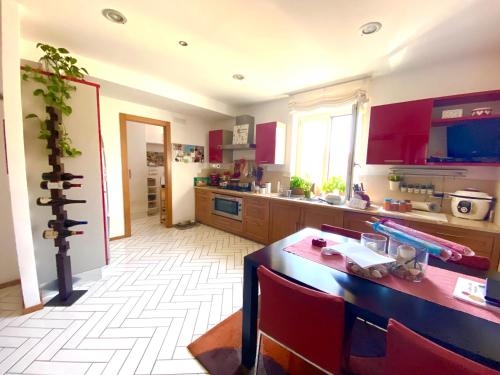 een keuken met rode kasten en een tafel met stoelen bij Seeview rooftop house between Sorrento and Amalfi in Massa Lubrense