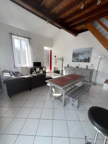 un salon avec une table et un canapé dans l'établissement La Petite Angerienne, à Saint-Jean-dʼAngély