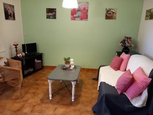 ein Wohnzimmer mit einem Bett und einem Tisch in der Unterkunft Gite à 5mn des plages et à 5mn de Granville in Longueville