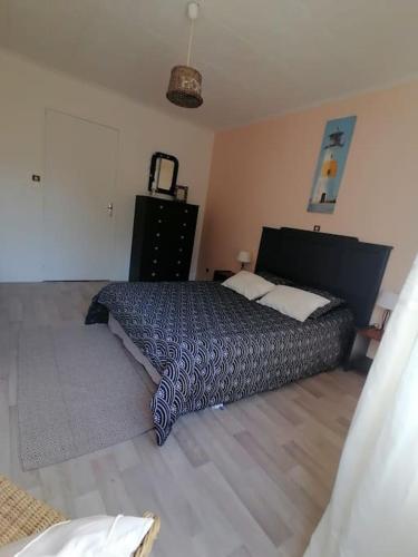 une chambre avec un lit et une commode dans l'établissement Gite à 5mn des plages et à 5mn de Granville, à Longueville