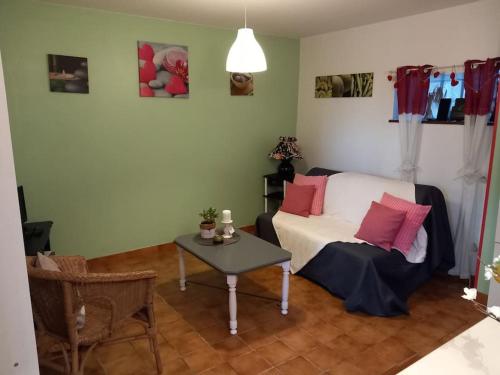 Schlafzimmer mit einem Bett mit rosa Kissen und einem Tisch in der Unterkunft Gite à 5mn des plages et à 5mn de Granville in Longueville