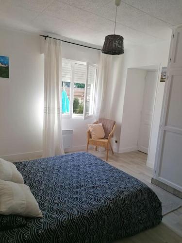 une chambre avec un lit, une chaise et des fenêtres dans l'établissement Gite à 5mn des plages et à 5mn de Granville, à Longueville