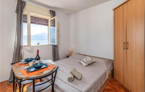 a bedroom with a bed with a table and a window at Nice Apartment In Rijeka With House Sea View in Rijeka