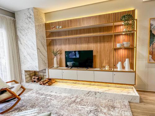 Televisyen dan/atau pusat hiburan di Apto moderno com lareira, piscina aquecida e infra completo em Gramado