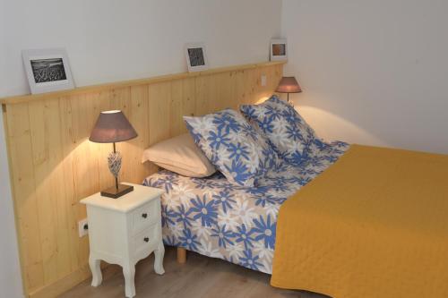 - une chambre avec un lit et une lampe sur une table de chevet dans l'établissement Logement spacieux au calme - Plage des Chalets, à Gruissan